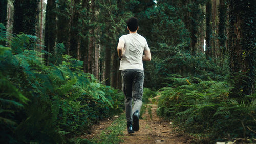 Boy trains by running on a trail in the mountains at night