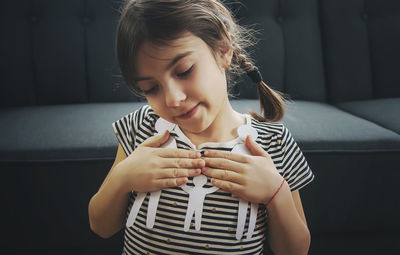 Happy girl with paper craft sitting at home