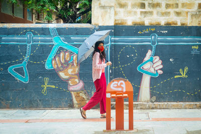 Woman with graffiti on wall