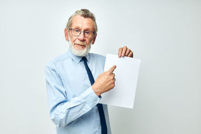 Portrait of businessman standing against white background