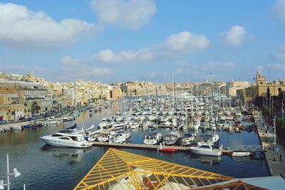 Boats moored in harbor against buildings in city