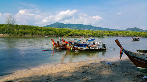 Boats moored on river against sky