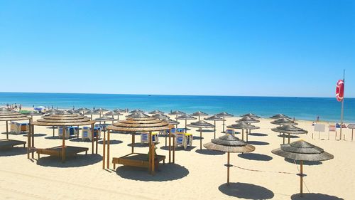 High angle view of parasols at beach against clear blue sky