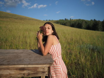 Portrait of young woman standing on field