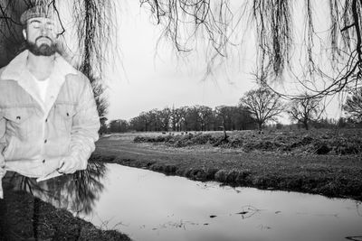 Double exposure of man standing by lake against sky