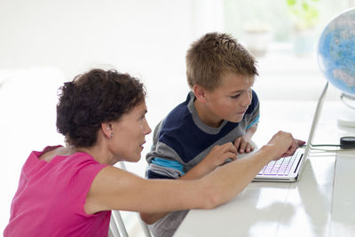 Mother and son using laptop