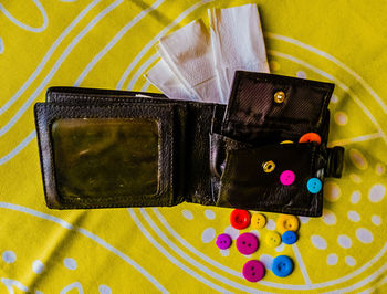 High angle view of wallet and buttons on table