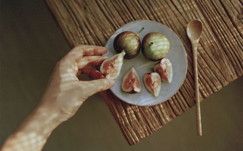 Cropped hand of person holding fig