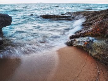 Waves splashing amidst rocks at beach