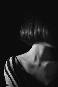 Close-up of woman with short hair against black background