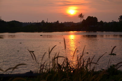 Scenic view of lake against orange sky