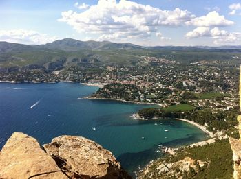 Aerial view of city by sea against sky