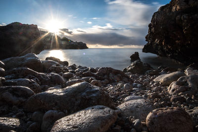 Rocks by sea against sky