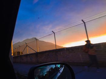 Car on road against sky during sunset