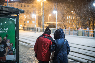 Rear view of people on snow covered at night