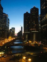 Illuminated buildings in city against sky