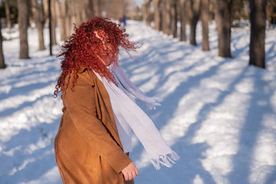 Rear view of woman standing on snow covered field