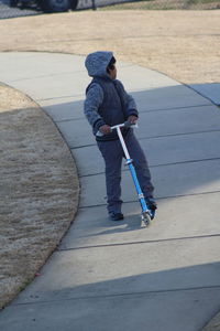 Full length of boy playing on push scooter