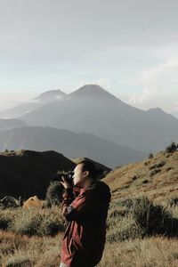 Man standing on field against mountains