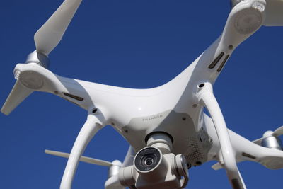 Low angle view of airplane against clear blue sky