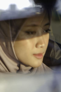 Close-up of young woman in car