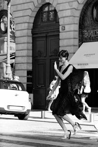 Woman with umbrella on road in city