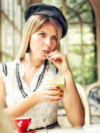 Portrait of beautiful young woman drinking glass