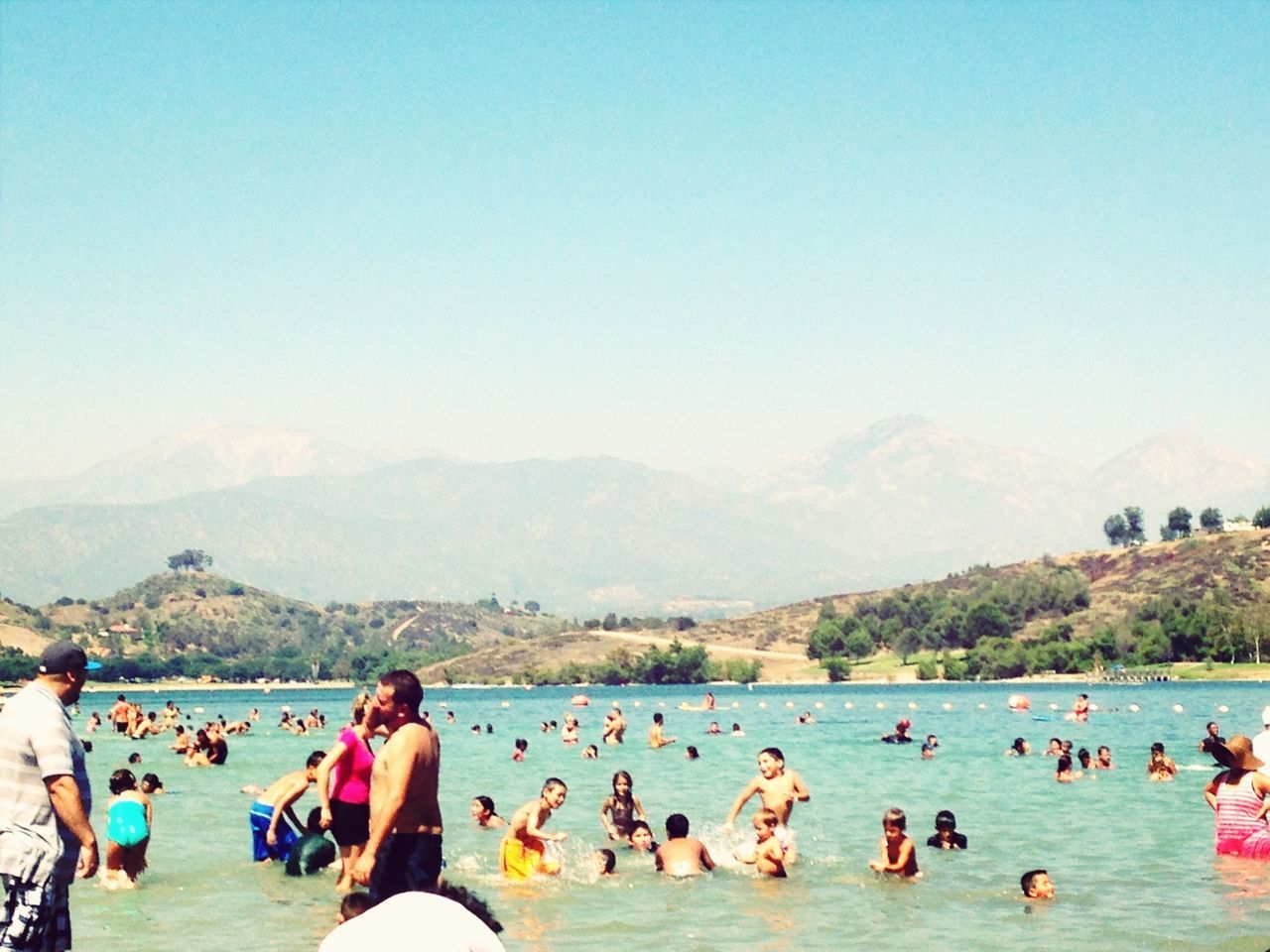 large group of people, water, leisure activity, lifestyles, mountain, enjoyment, sea, vacations, mixed age range, person, clear sky, beach, copy space, men, blue, fun, scenics, nature, tourist