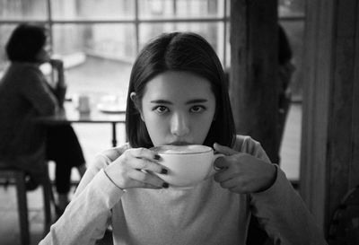 Portrait of woman drinking coffee in cafe