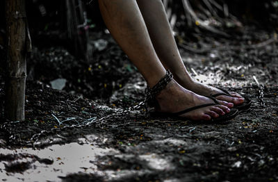 Low section of woman standing on mud