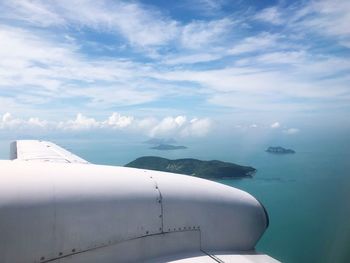 Airplane flying over sea against sky