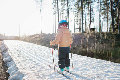 Young boy cross country skiing in sweden at sunset