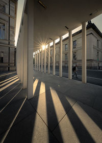 Illuminated street light by building in city