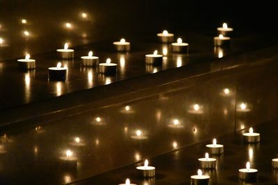 Illuminated candles against building