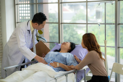 Rear view of doctor examining patient in office