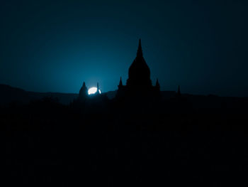 Silhouette of temple against clear sky at night