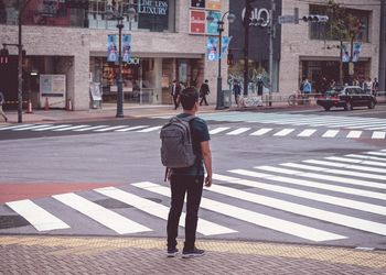 Rear view of man crossing road