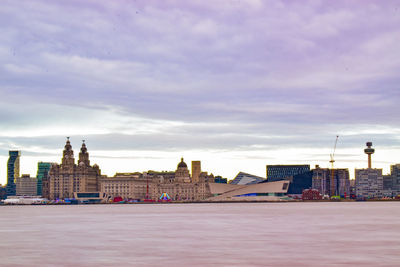 Buildings in city against cloudy sky