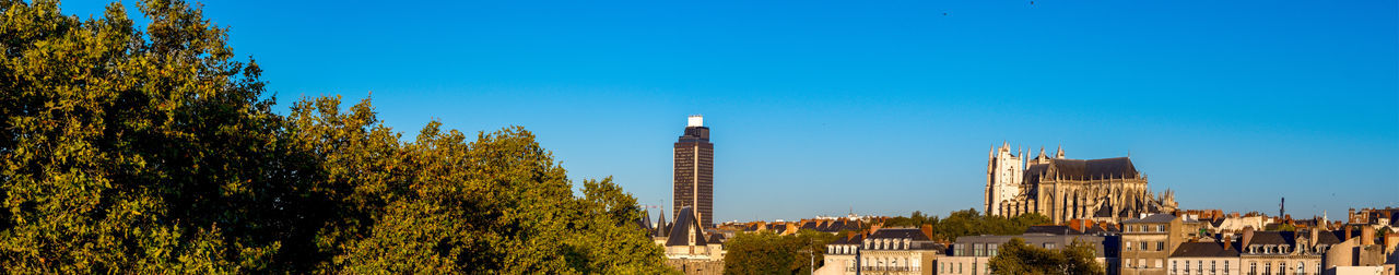 Panoramic view of buildings against blue sky