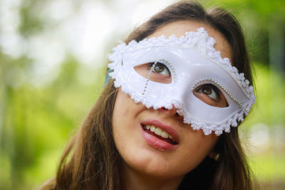 Smiling young woman wearing venetian mask