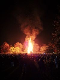 Crowd at music concert against sky at night