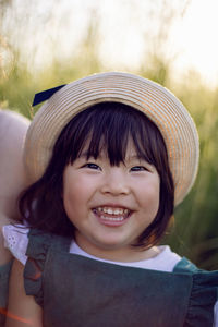 Koreans family mother and daughter in green dresses sitting in the long grass on the field at sunset