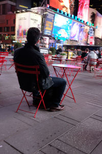 Rear view of man sitting outdoors
