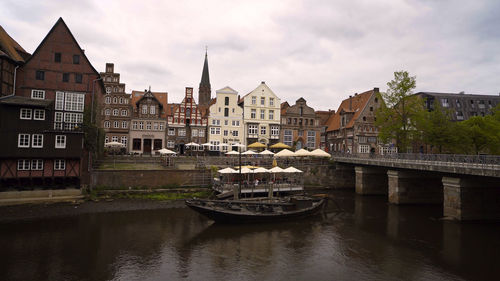 Bridge over river in city against sky