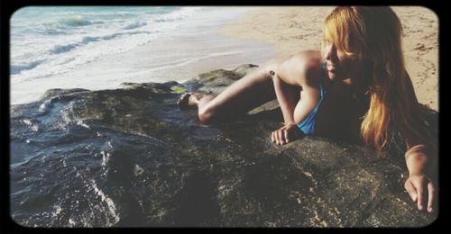 Woman relaxing on rocks at beach