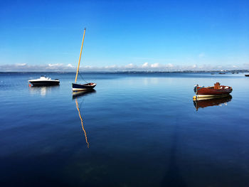 Ship moored on sea against blue sky