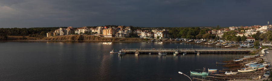 Panoramic view of city buildings by sea against sky