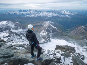 Mountaineer enjoying views on alpine landscape after reaching peak summit, austrian alps, europe