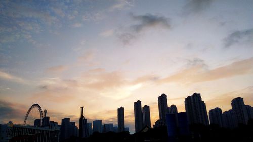 Silhouette buildings against sky during sunset