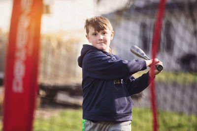 Portrait of cute boy playing baseball on field